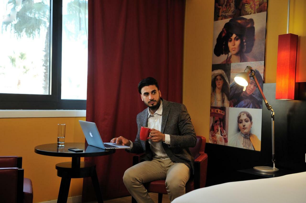 Hotel Mercure Alger Aeroport Maison Blanche Bagian luar foto A man working on a laptop